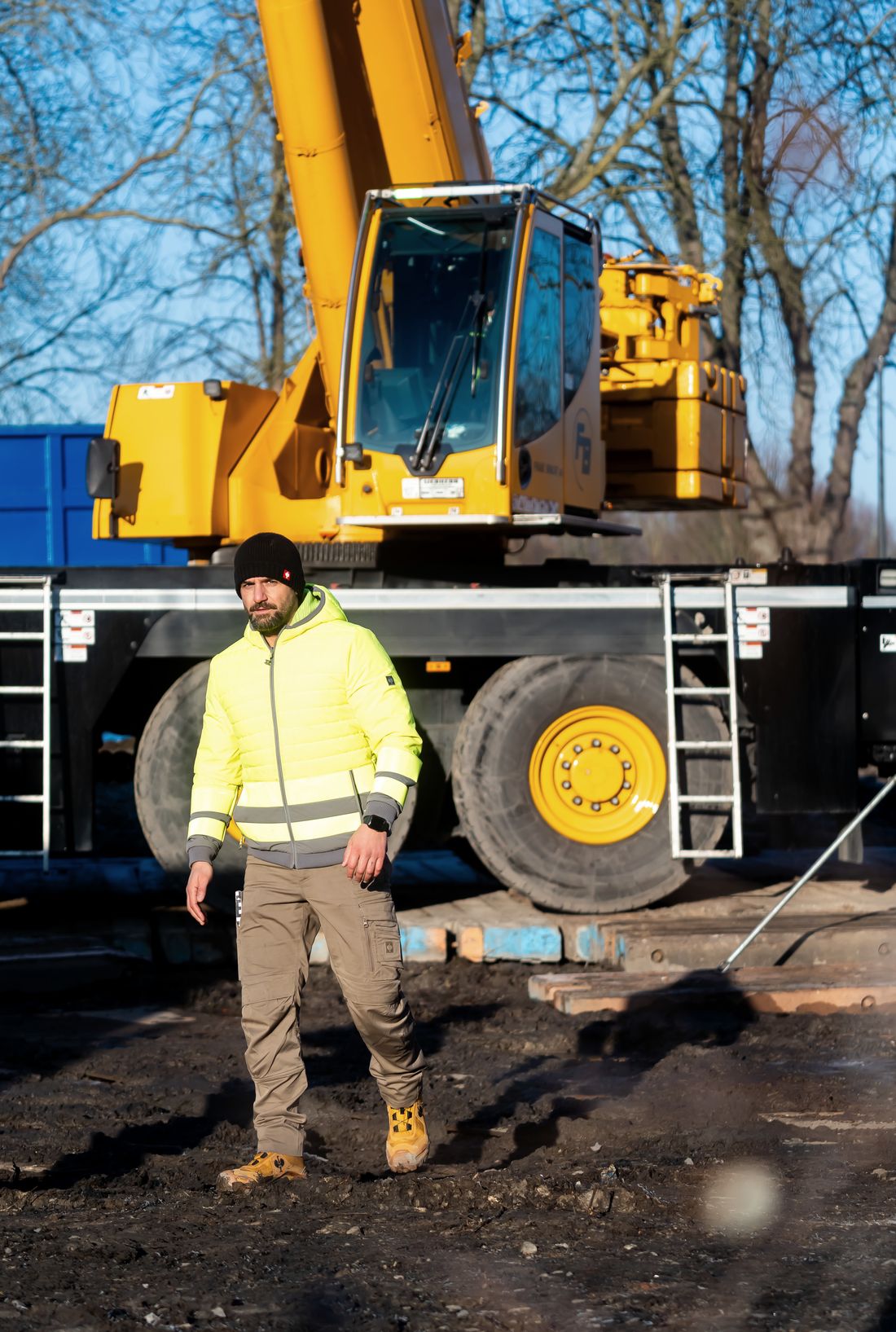 Lek Bitic auf der Baustelle vor einem Mobilkran